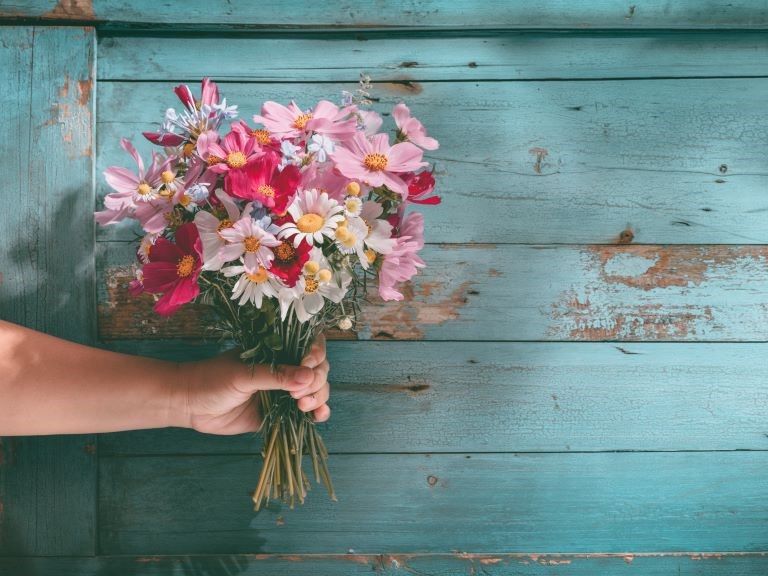 Arm mit Blumenstrauss in der Hand